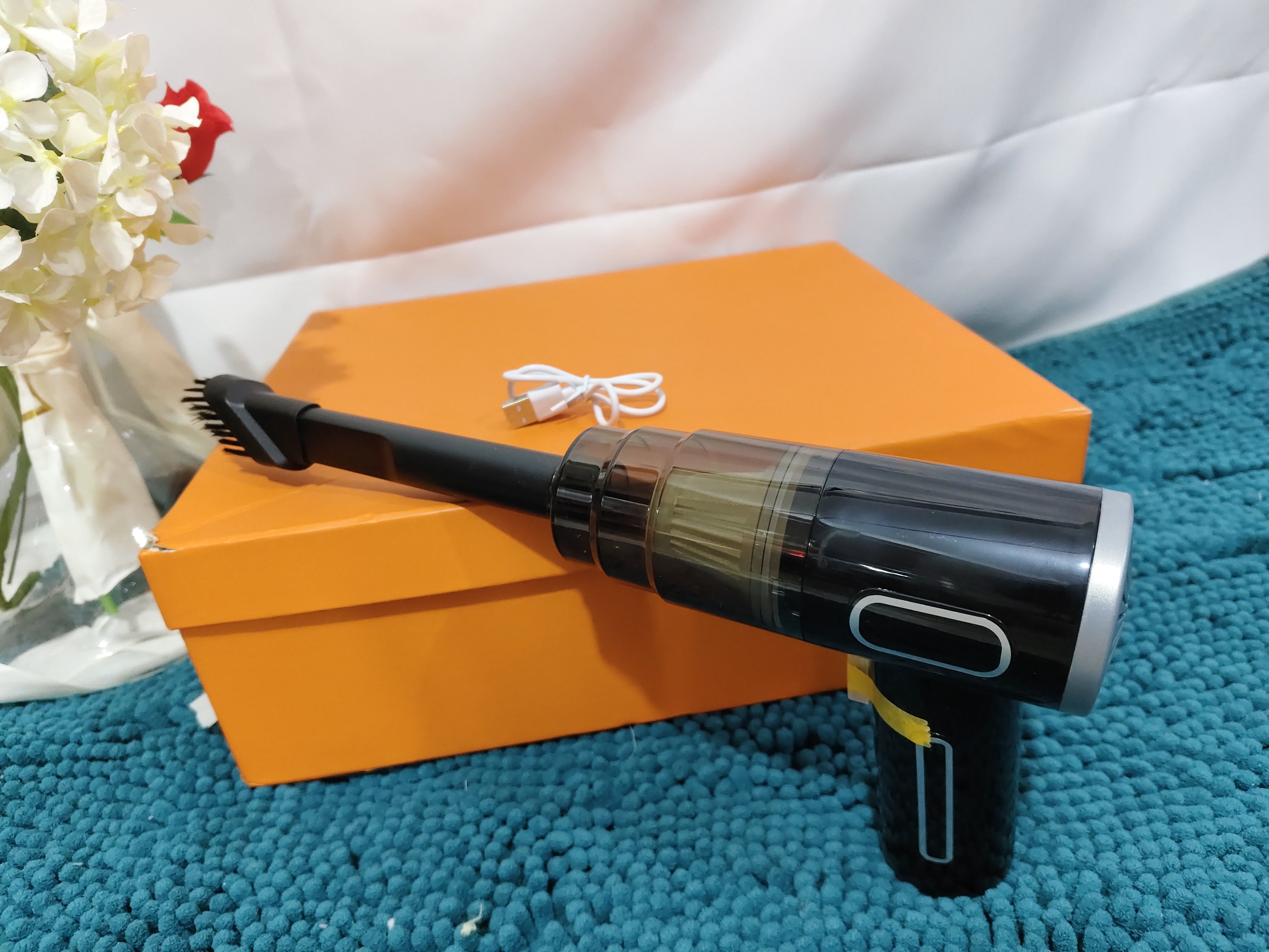 PureGlow portable car vacuum cleaner, compact car accessory with hose attachment for cleaning vehicle interior surfaces.