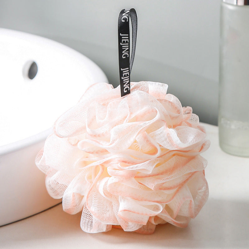 PureGlow soft bubble bath loofah ball for gentle exfoliation and luxurious bathing, shown hanging with a white towel in the background.